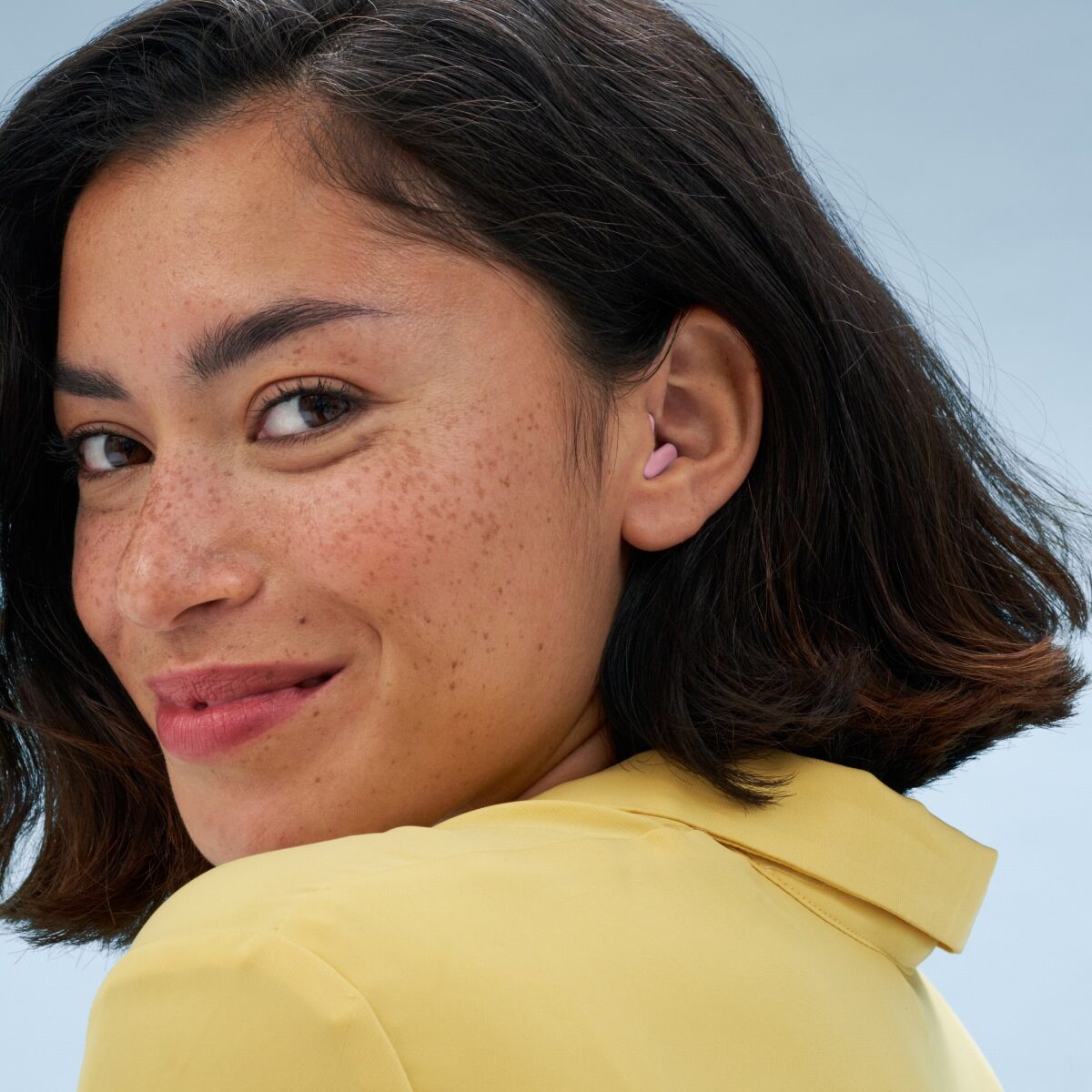 A woman is happy while wearing Alpine Silence earplugs.