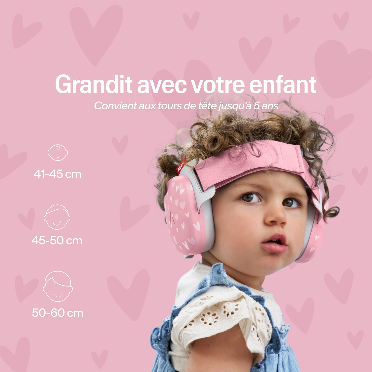 Baby wearing a pink muffy baby with certification text on a pink heart-patterned background