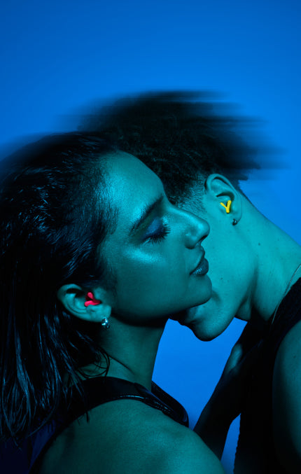 Two people close together with a blue filter, wearing Alpine Tune