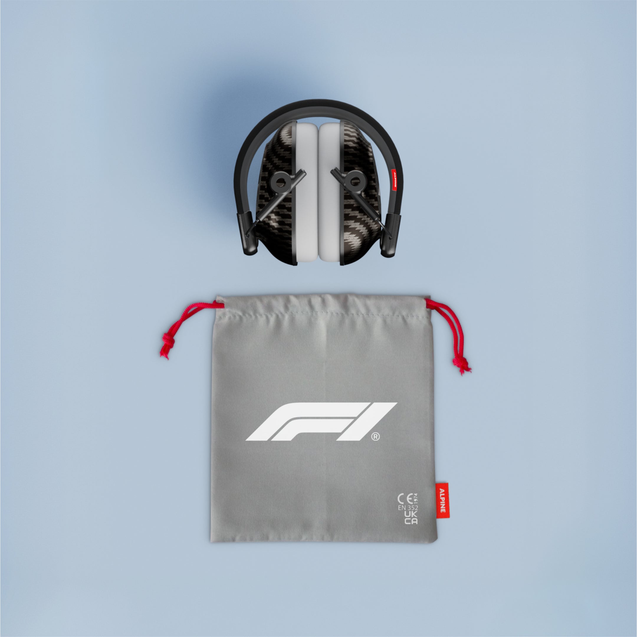 Folded Alpine Formula 1 Racing Muffy earmuffs above a grey drawstring pouch with red cords and F1 logo
