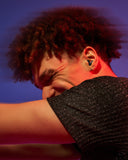 guy wearing alpine tune earplugs in black dancing at a party