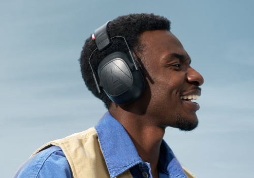 Man wearing headphones with a clear blue sky background