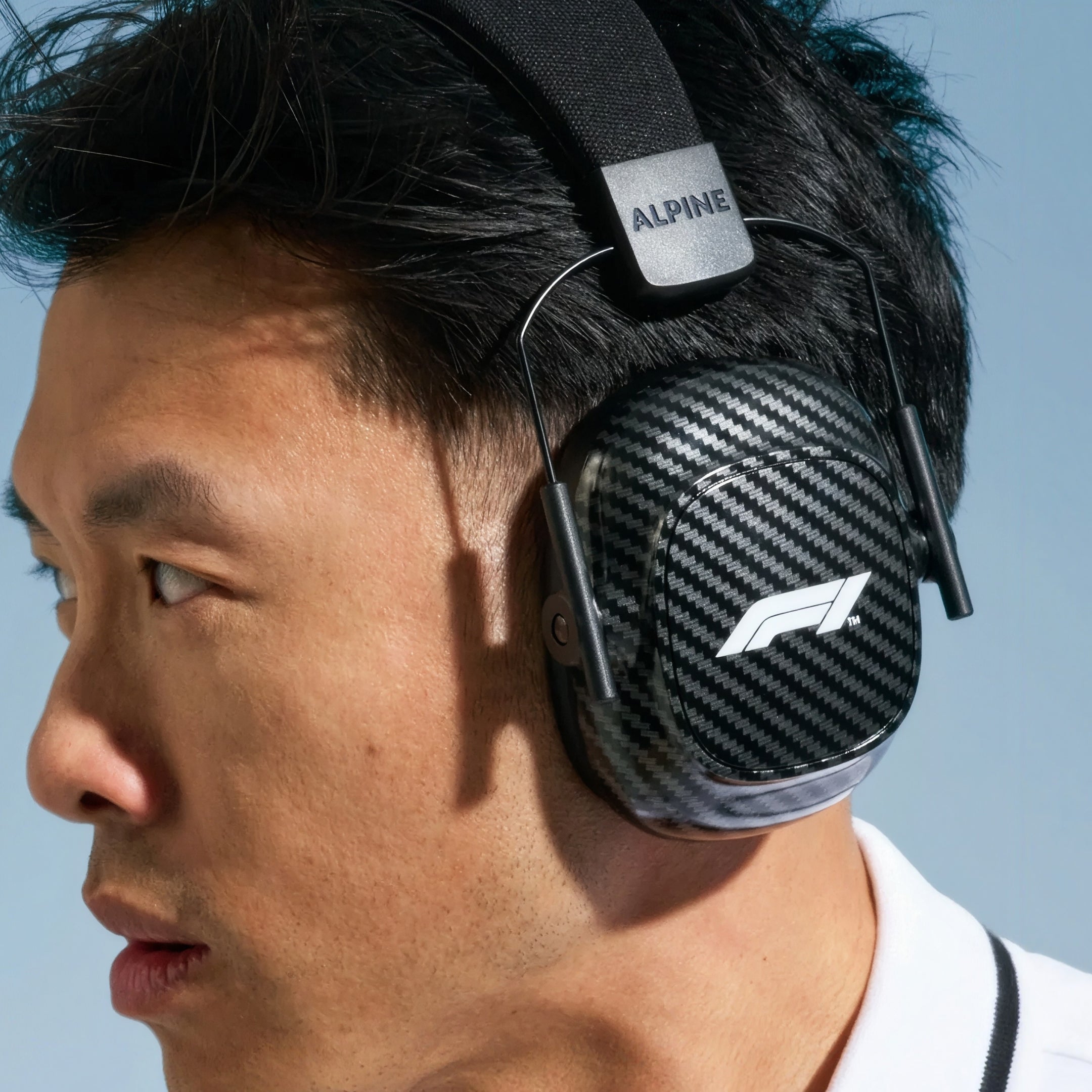 Man with short dark hair wearing Alpine Formula 1 Earmuffs, side view