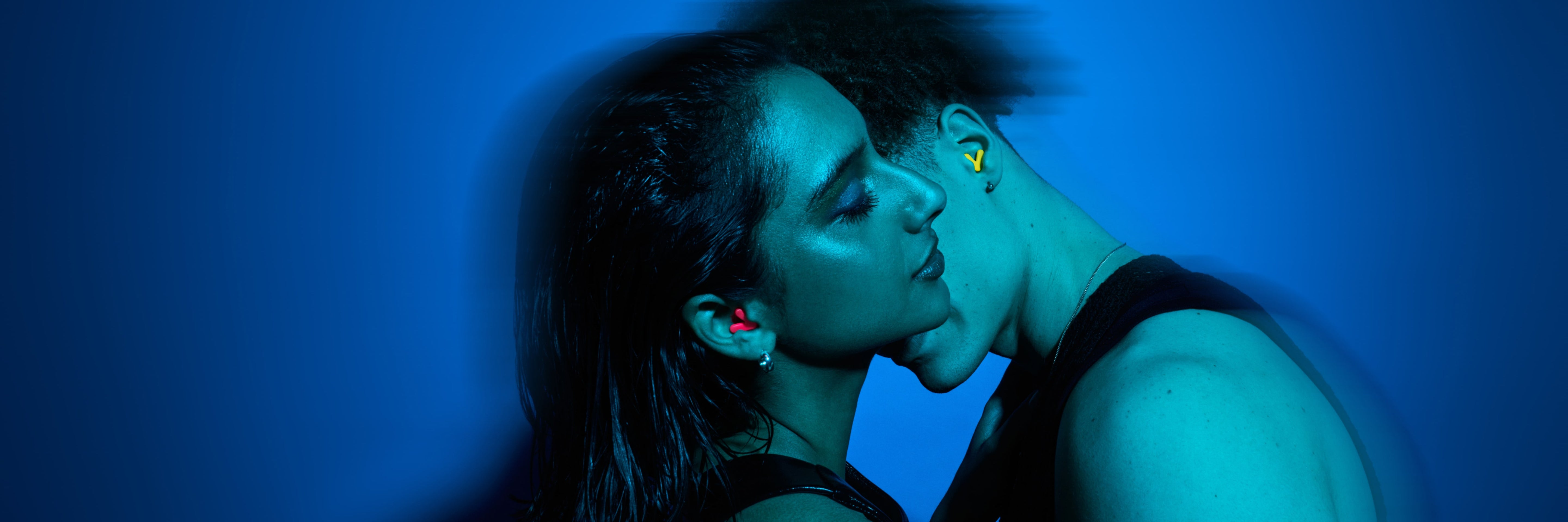 Two people close together with a blue filter, wearing Alpine Tune