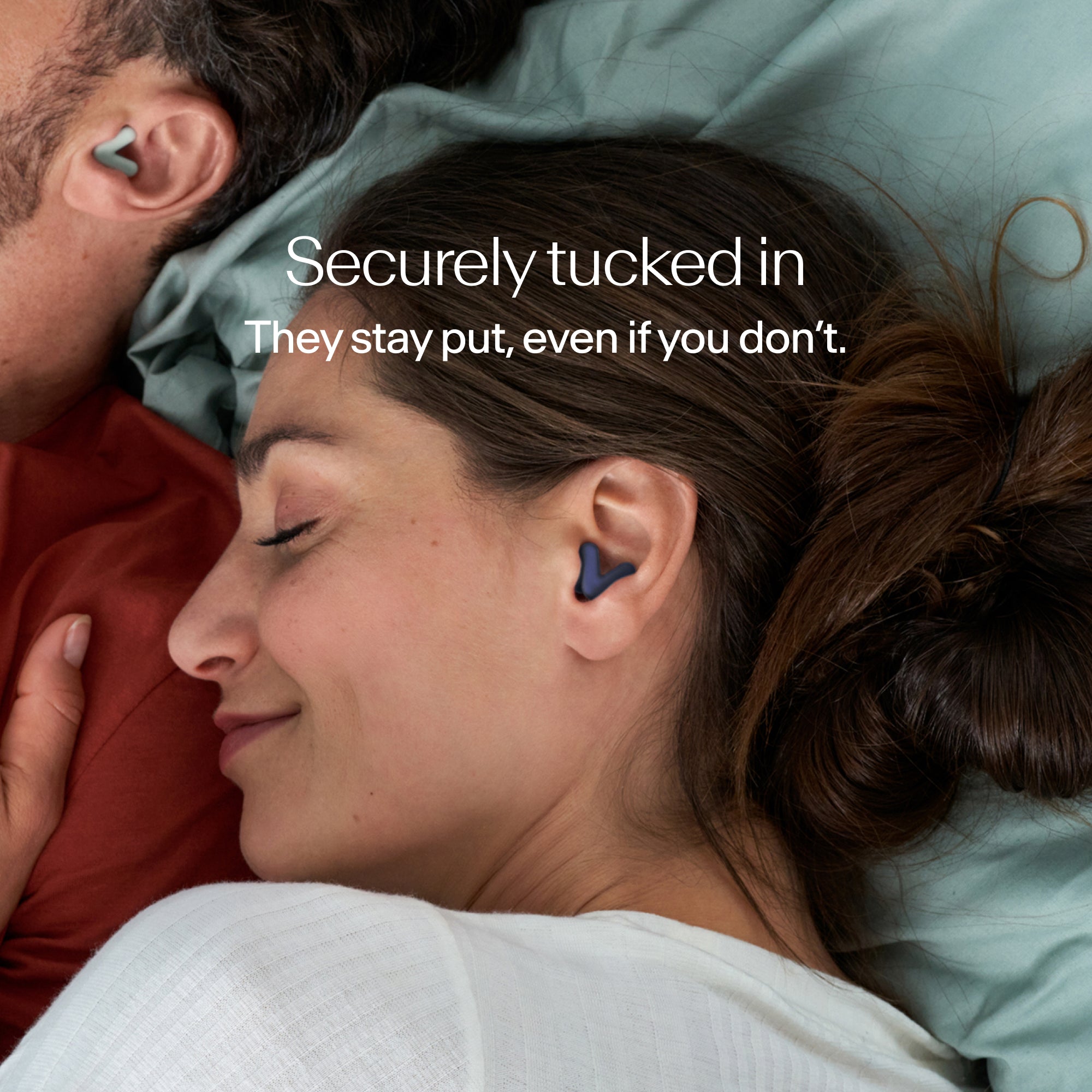 Man and woman sleeping, wearing Alpine Silence earplugs in midnight blue that stay securely in place 