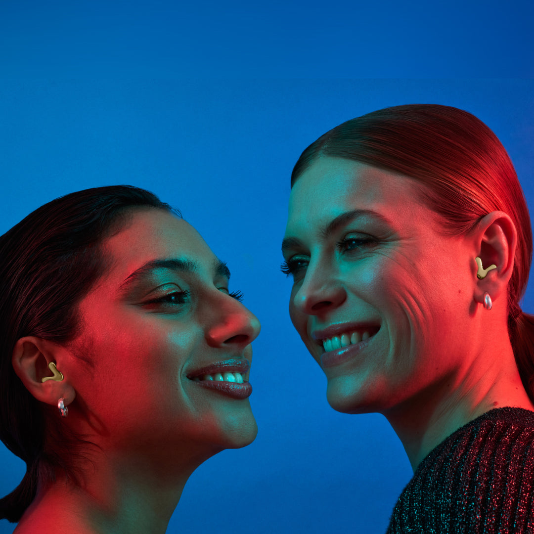 Two women with Alpine Tune in rose-gold and silver dance together 